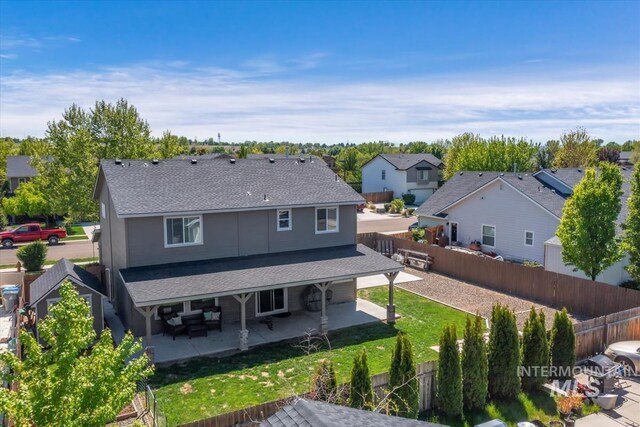 back of house with a residential view, a patio area, roof with shingles, and a fenced backyard