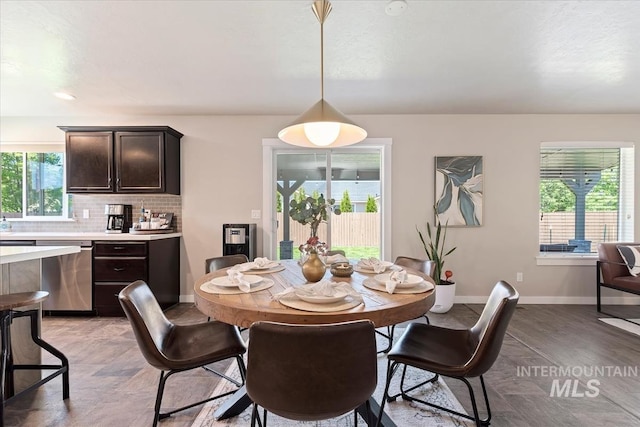 dining area with baseboards and light wood finished floors