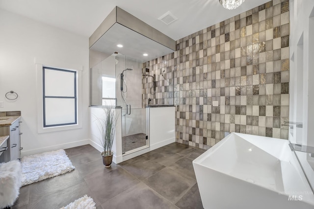 1580 Clear Creek Loop, Twin Falls, ID 83301 - full bathroom featuring tile walls, a soaking tub, a stall shower, vanity, and baseboards