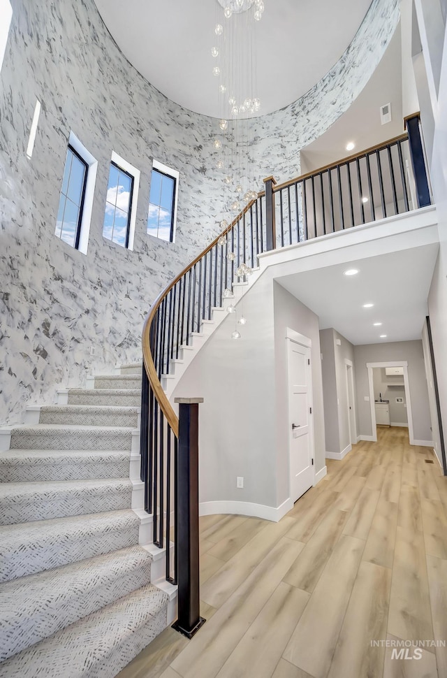 1580 Clear Creek Loop, Twin Falls, ID 83301 - stairs featuring a towering ceiling, baseboards, wood finished floors, a chandelier, and recessed lighting