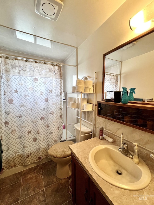 full bathroom featuring vanity, a shower with shower curtain, and toilet