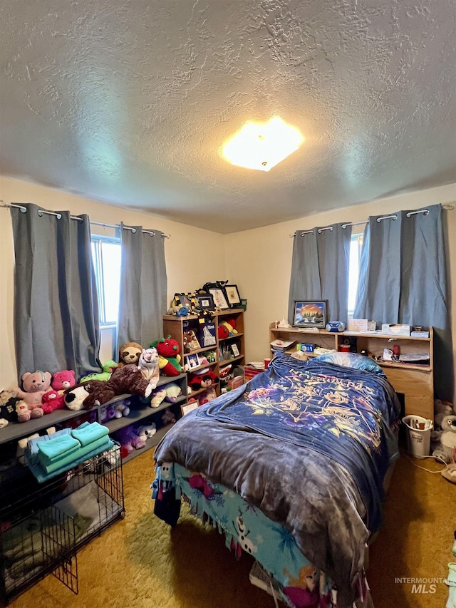 bedroom with carpet floors and a textured ceiling