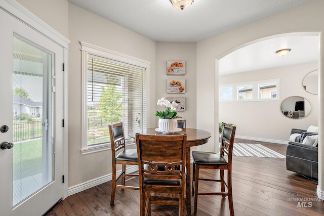 1175 N Champions Pl, Eagle, ID 83616 - dining area featuring arched walkways, baseboards, and dark wood-style flooring