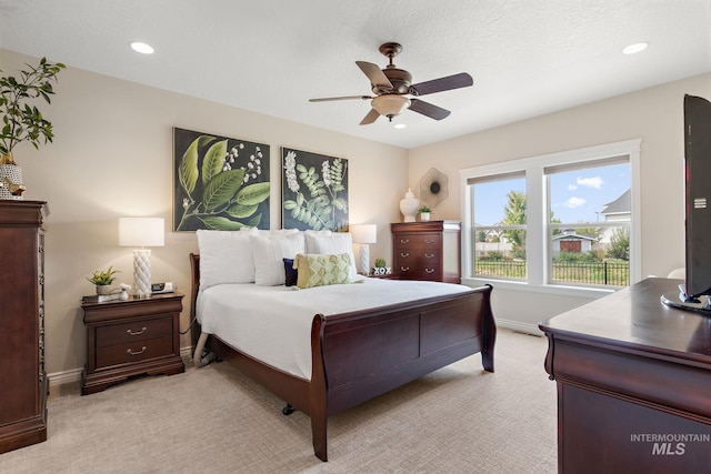 carpeted bedroom with ceiling fan and a textured ceiling