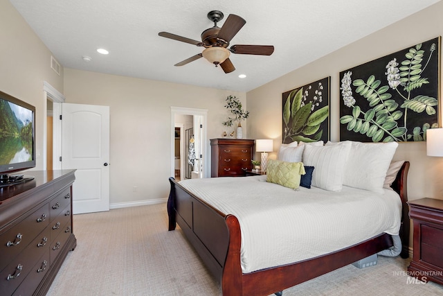 carpeted bedroom with ensuite bathroom and ceiling fan