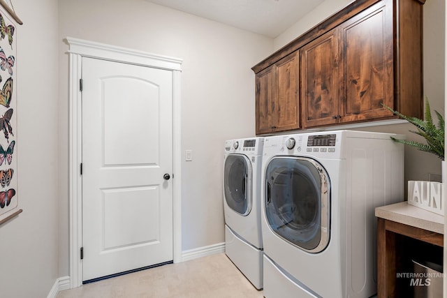 clothes washing area with cabinets and independent washer and dryer