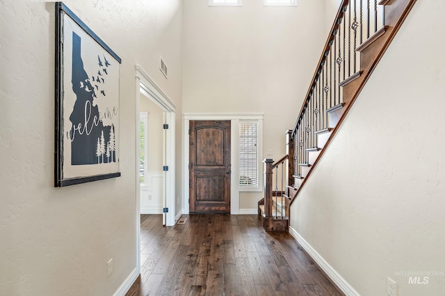 entryway with a high ceiling and dark hardwood / wood-style flooring