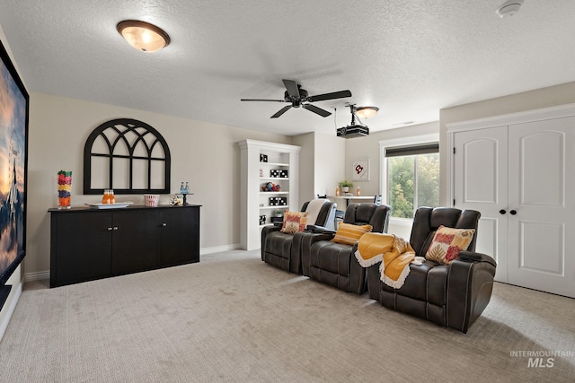 living room featuring light colored carpet, a textured ceiling, a fireplace, and ceiling fan