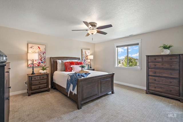 carpeted bedroom with ceiling fan and a textured ceiling