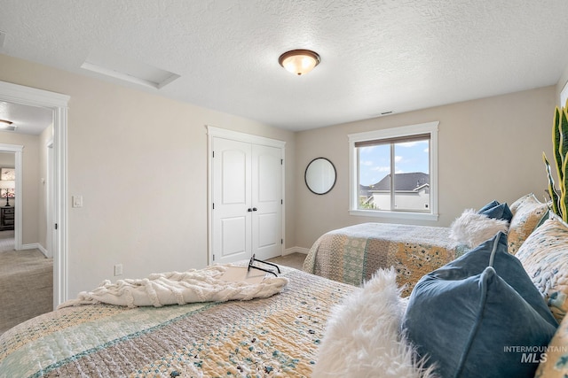 bedroom featuring a textured ceiling and carpet floors