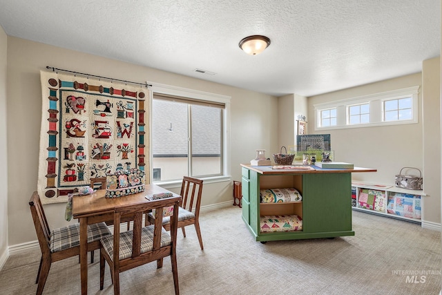 dining area featuring a textured ceiling and carpet