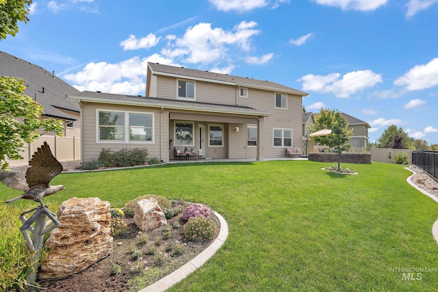 back of house with a lawn and a patio area