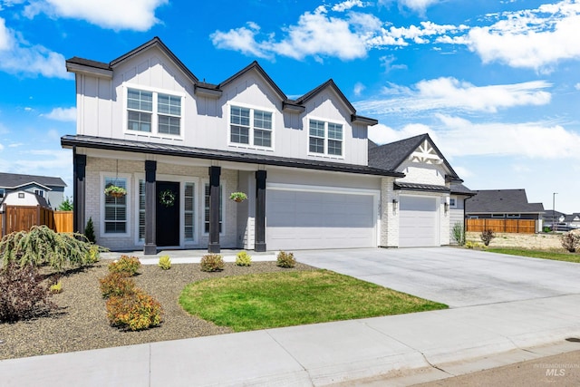 view of front facade with fence, a porch, concrete driveway, brick siding, and board and batten siding