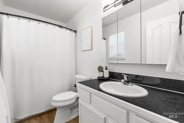bathroom featuring wood finished floors, toilet, vanity, and a shower with curtain
