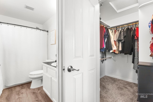 full bath with toilet, vanity, wood finished floors, and curtained shower