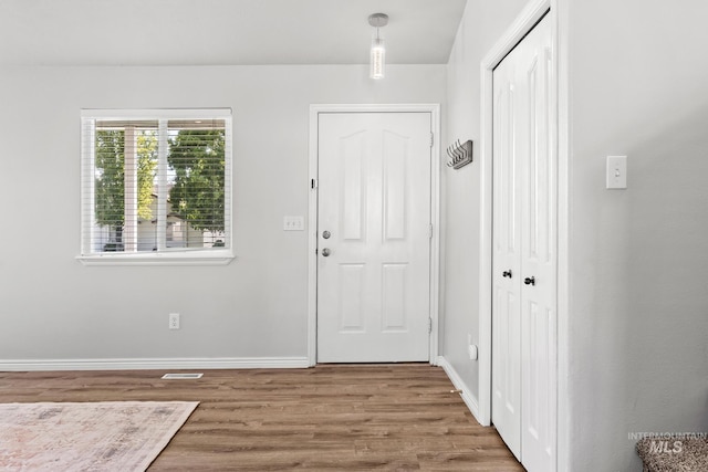 foyer entrance featuring wood finished floors and baseboards