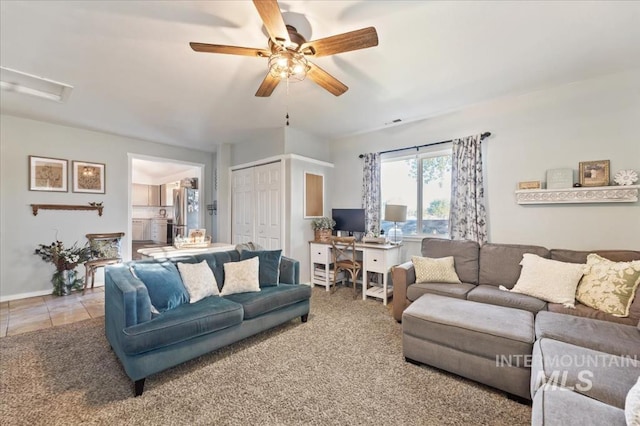 living area with a ceiling fan, a desk, and baseboards