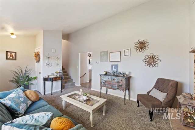 living area featuring carpet, vaulted ceiling, stairs, and baseboards