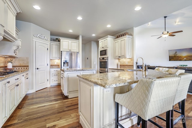 4049 Quail Ridge Dr, Kimberly, ID 83341 - kitchen featuring a center island, a sink, appliances with stainless steel finishes, wood finished floors, and light stone counters