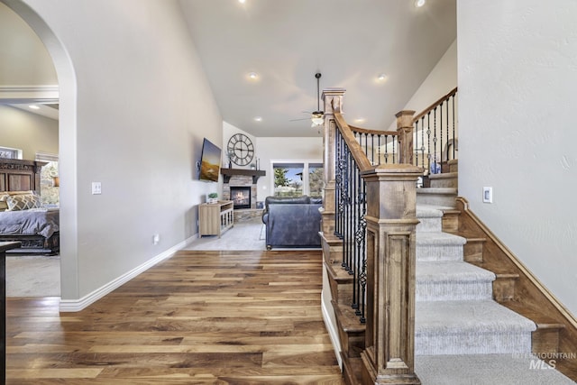 4049 Quail Ridge Dr, Kimberly, ID 83341 - stairway with arched walkways, a ceiling fan, a fireplace, wood finished floors, and high vaulted ceiling
