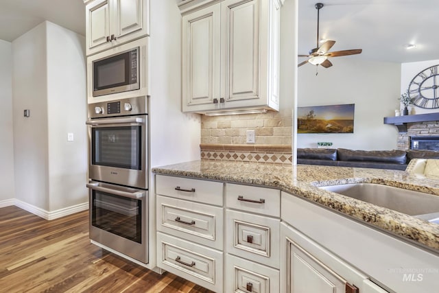 4049 Quail Ridge Dr, Kimberly, ID 83341 - kitchen featuring open floor plan, ceiling fan, wood finished floors, stainless steel appliances, and backsplash