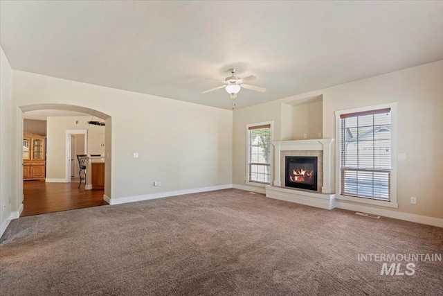 11871 W Wilmont St, Boise, ID 83709 - unfurnished living room featuring carpet flooring, ceiling fan, a glass covered fireplace, and baseboards