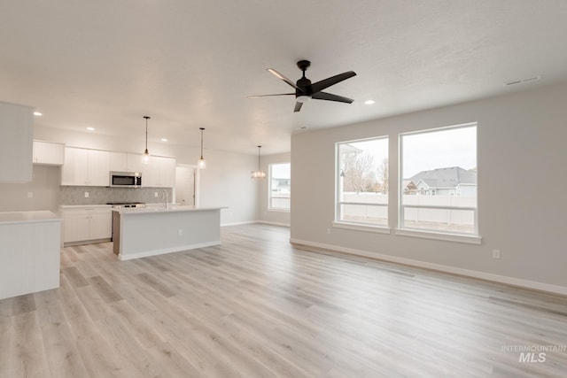 unfurnished living room featuring light hardwood / wood-style floors and ceiling fan