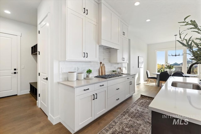 kitchen featuring a sink, dark wood-type flooring, stainless steel gas stovetop, and white cabinetry