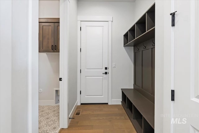 mudroom with visible vents, baseboards, and light wood-style floors