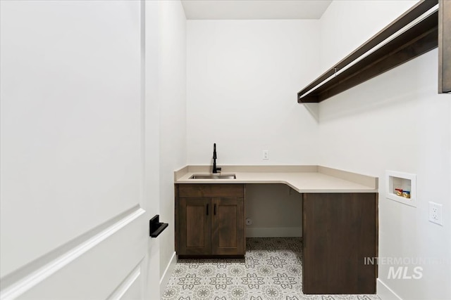 washroom with cabinet space, washer hookup, baseboards, and a sink