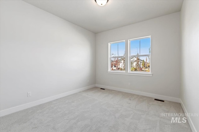 unfurnished room featuring visible vents, baseboards, and light colored carpet