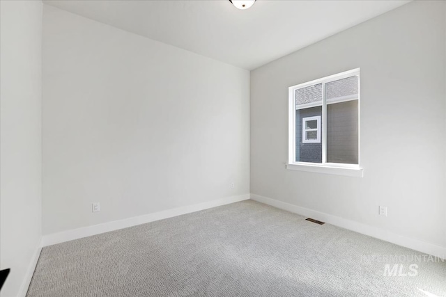 carpeted empty room with visible vents and baseboards