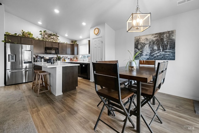 dining room with visible vents, lofted ceiling, recessed lighting, a notable chandelier, and light wood-type flooring