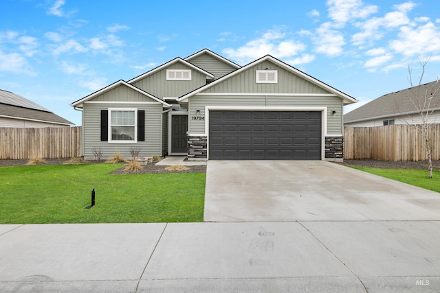 view of front facade featuring a garage, concrete driveway, a front lawn, and fence