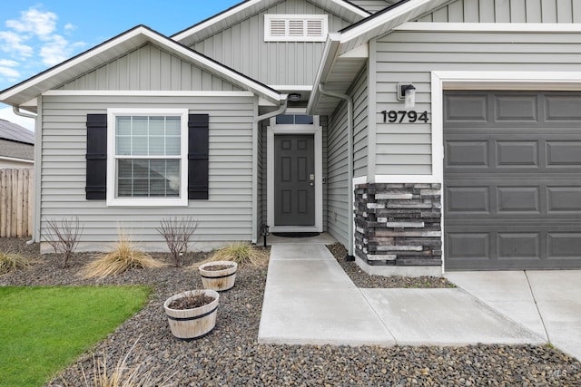 view of exterior entry with a garage and board and batten siding