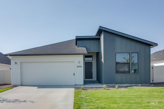 view of front of property with board and batten siding, a garage, driveway, and fence