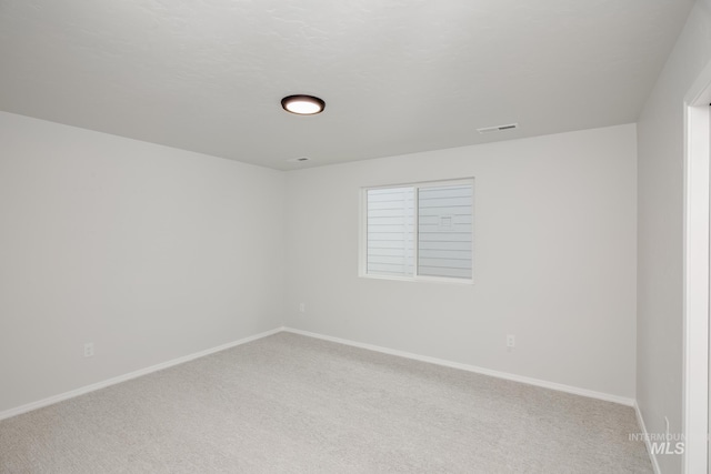 empty room featuring light carpet, baseboards, and visible vents