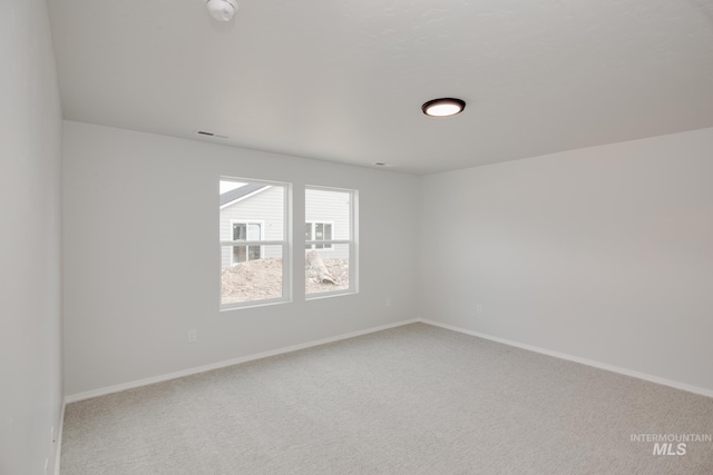 unfurnished room featuring light carpet, baseboards, and visible vents