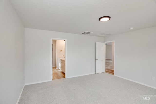 unfurnished bedroom with light carpet, baseboards, and visible vents