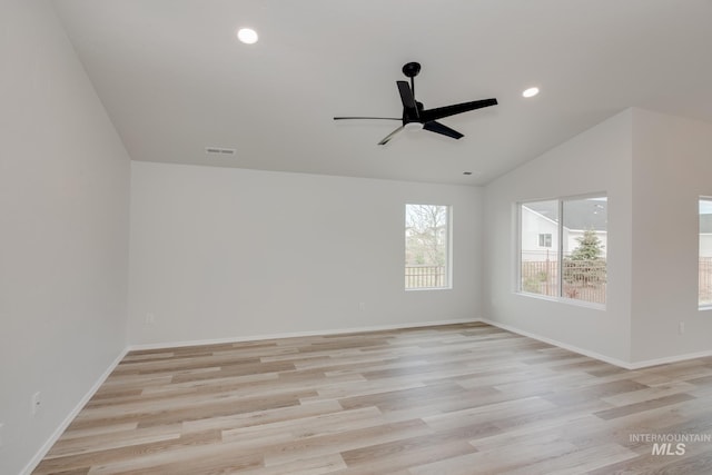 empty room featuring baseboards, lofted ceiling, a ceiling fan, and light wood-style flooring
