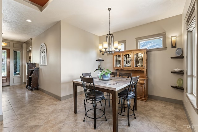 4763 S Skyridge Way, Boise, ID 83709 - dining space featuring a chandelier, baseboards, a textured ceiling, and light tile patterned flooring