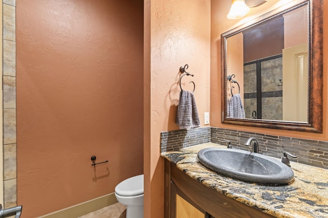 4763 S Skyridge Way, Boise, ID 83709 - bathroom featuring toilet, vanity, tile patterned floors, backsplash, and a textured wall