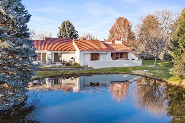 rear view of property with a yard and a water view