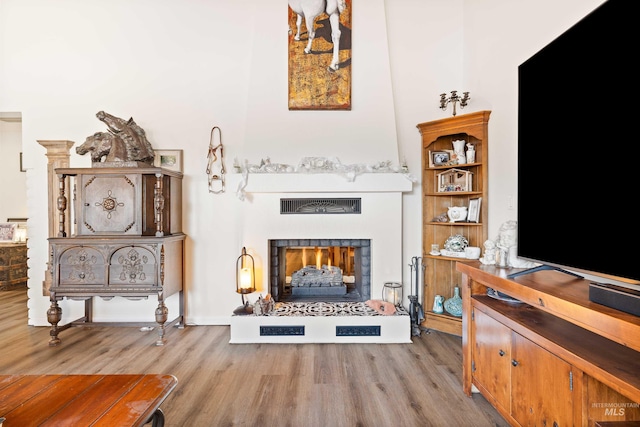 sitting room with light wood-type flooring and a fireplace