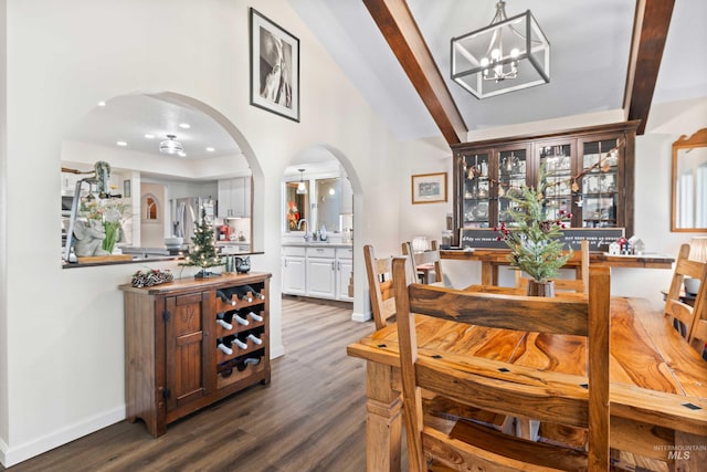 dining space featuring an inviting chandelier, dark wood-type flooring, and sink