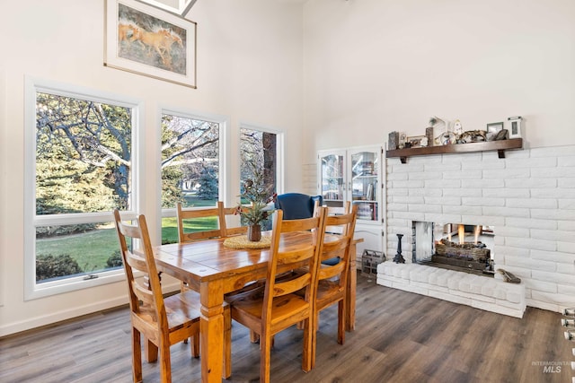 dining room featuring dark hardwood / wood-style flooring and a brick fireplace