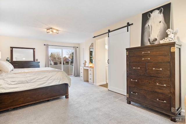 carpeted bedroom featuring a barn door and access to outside