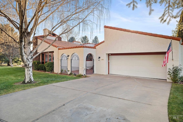 mediterranean / spanish house featuring a garage and a front lawn