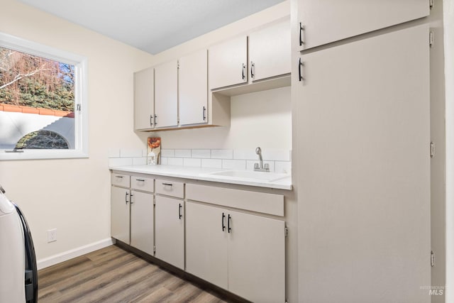 kitchen with white cabinets, dark hardwood / wood-style floors, sink, and washer / clothes dryer