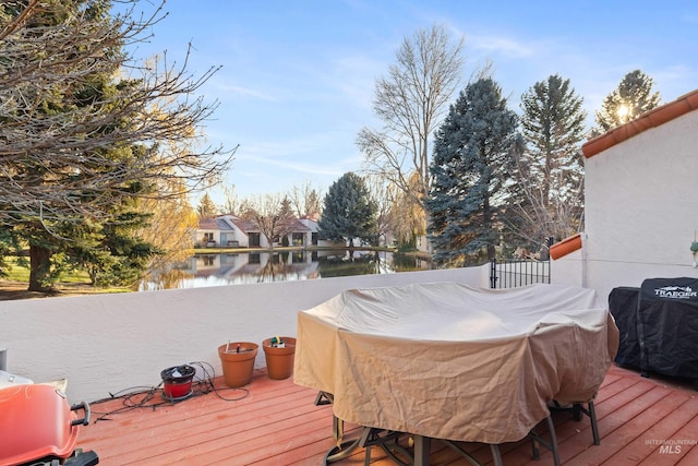 wooden deck with a water view and grilling area